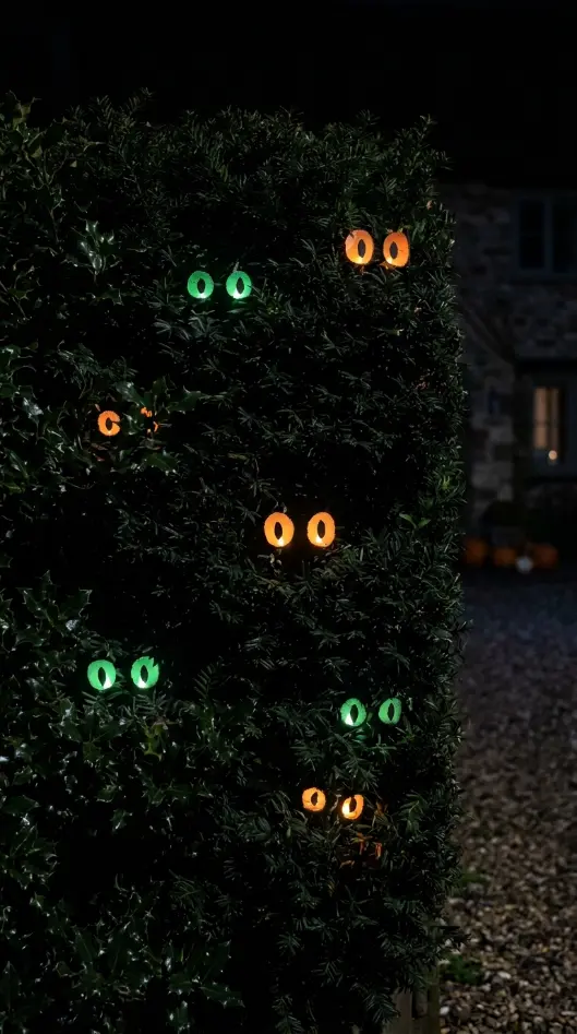 16 Outdoor Halloween Decorations Light-Up Pathway Night Style 9 9. The Glowing Eye Stakes in the Bushes